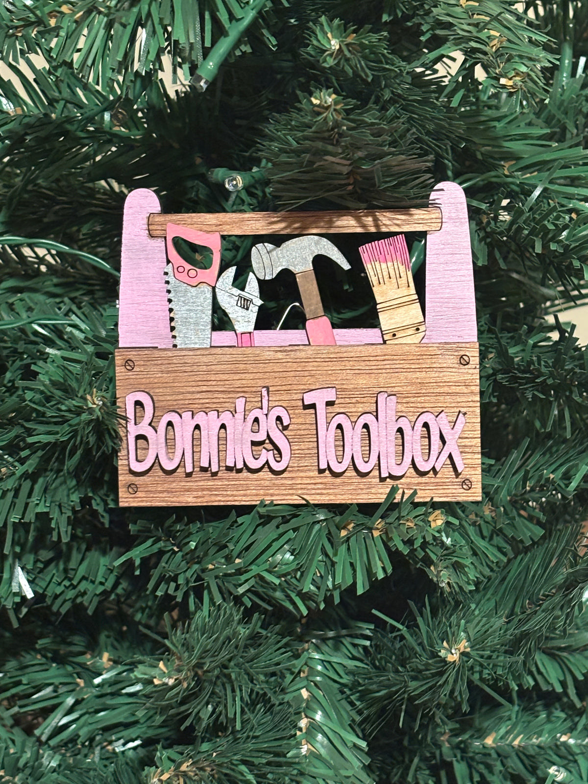  
This item is shown here is hanging on a Christmas tree. There's a hanger and 2 strong magnets on the back. It also comes with a perfectly sized easel.  
 3D Unique design, Handcrafted, this item is not printed. Its laser engraved and precision cut. 
The tools are removable and can be replaced in any slot you wish.

This item measures approximately 3.5" X 4.0 inches.